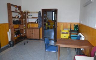 místnost obložena dřevem s dvěma stoly a regály s uskladněnými věcmi