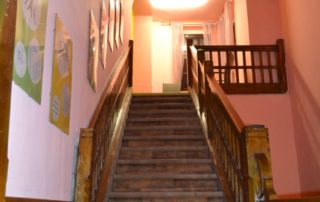 dřevěné schodiště focené zespoda, oranžově vymalované stěny