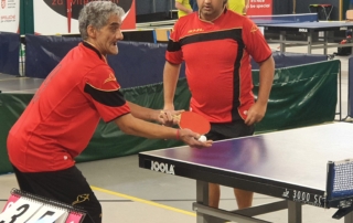 dva muži v červeném dresu hrající stolní tenis