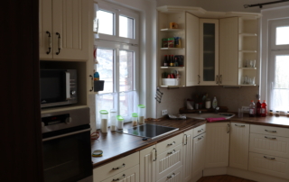 kuchyně v rustikálním stylu s krémovými skříňkami a moderními spotřebiči v nerezové úpravě